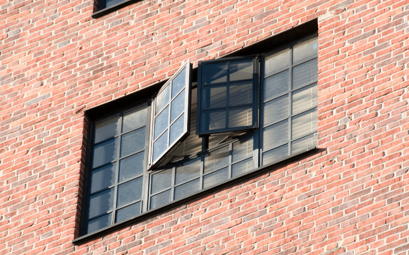 A flush casement timber window fitted in a brick wall.