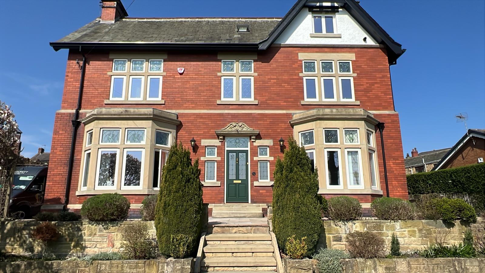 1920s red brick house with decorative glass casement windows