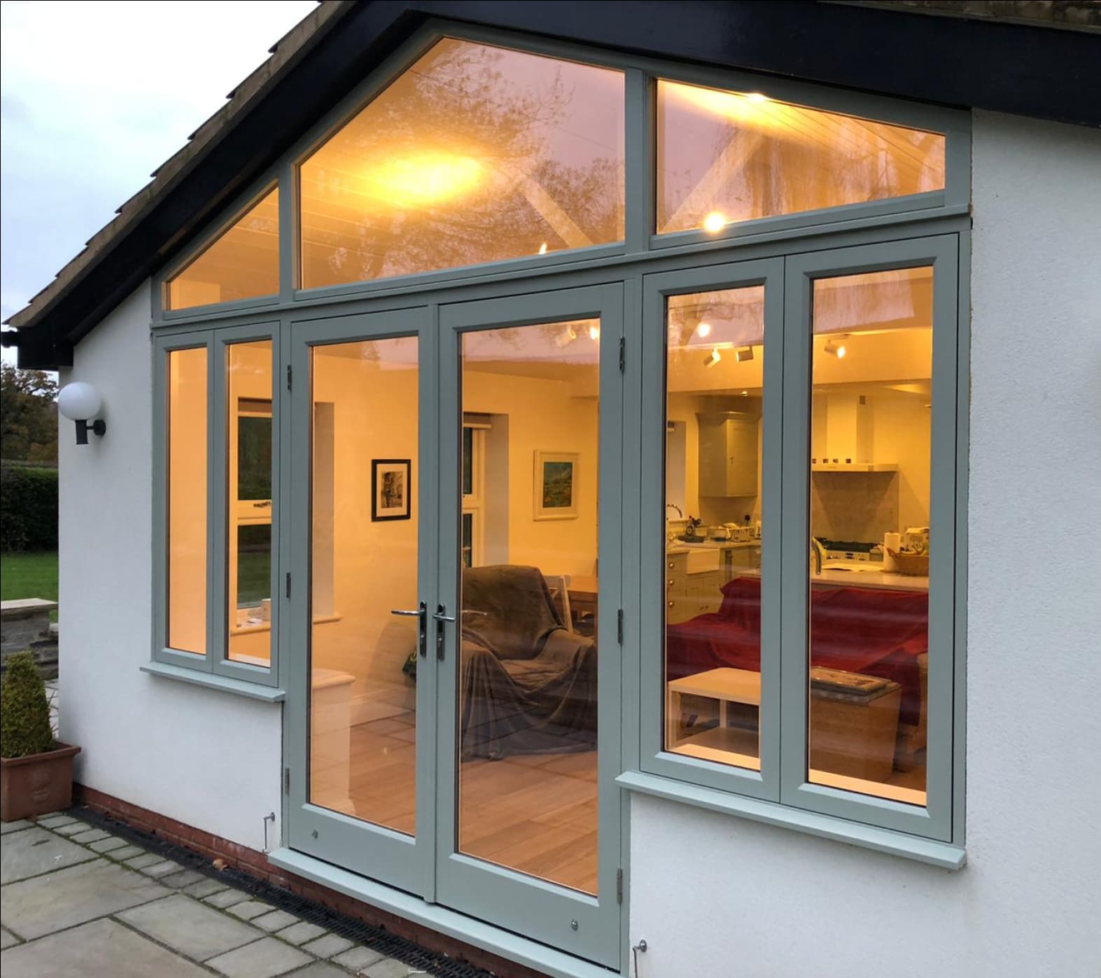 Conservatory with a cosy orange light and a bespoke arched window and door screen