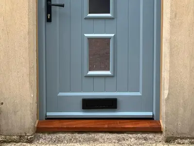 Pale blue timber door with a hardwood oiled cill