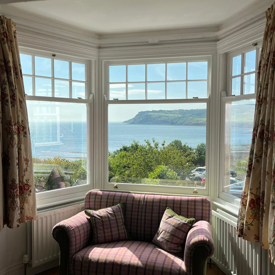 Spiral balance sash window with a view out over Robin Hoods Bay Yorkshire