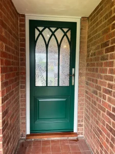 Gothic style Moss green door with decorative glass and a heavy bolection door