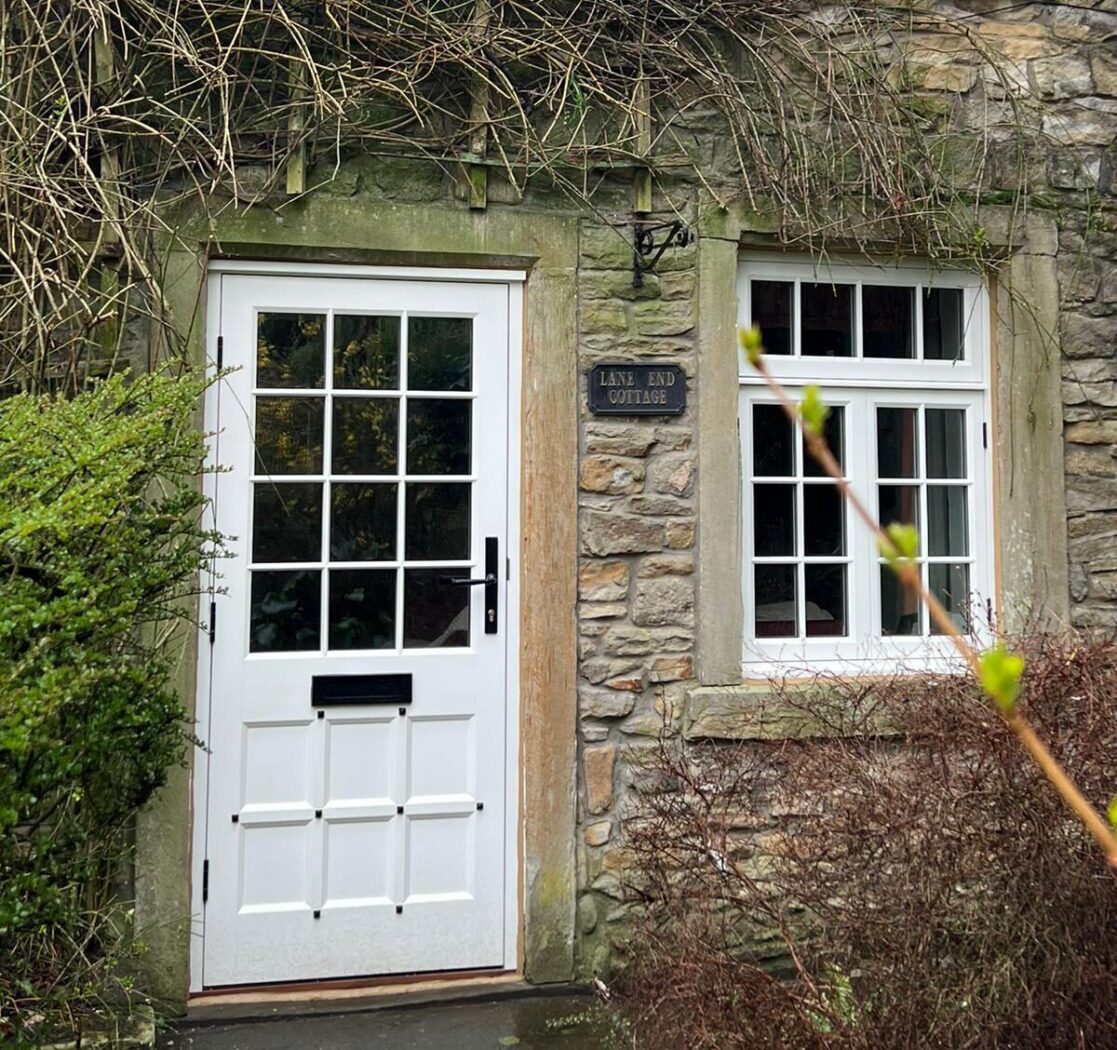 Cottage with White entrance door with studwork on the panel