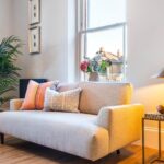 Living room with a grey sofa, potted plants and a new wooden window