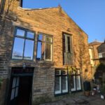 19th century building conversion in Bradford on a sunny winters day with green windows and balcony french doors
