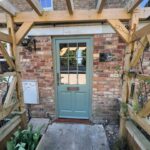 Patio with a Card Room Green entrance door and a timber arched trellis