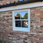 Square timber sash window in a red brick house