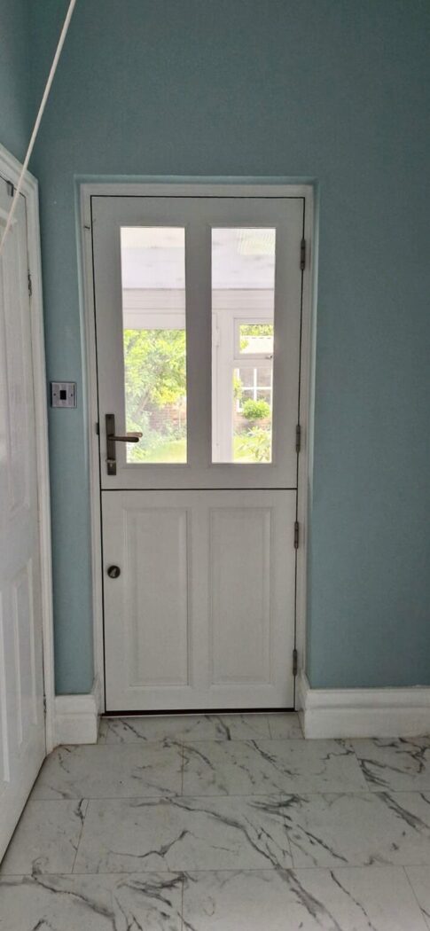 Entrance hall with white marble floors, light blue walls and a traditional wooden stable door