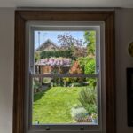 New sliding sash window with a view out of a garden on a summers day