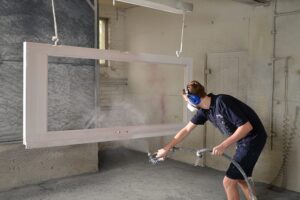 Joiner spraying window frames in the Patchett Joinery spray booth 