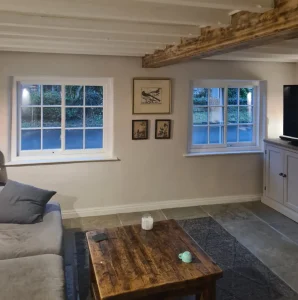 Cottage living room with exposed timber beams and two Yorkshire Sliding Sashes