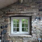 Stone pottery studio with a white timber window with traditional hardware
