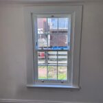 Living room on a sunny day with a white timber box sash window
