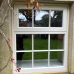 Stone cottage in Harrogate with a shaded white wooden flush casement window