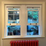 Living room with two sash windows fully open at the bottomj
