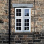 Traditional stone building with a new oriel bay window with georgian bars