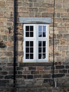 Traditional stone building with a new oriel bay window with georgian bars