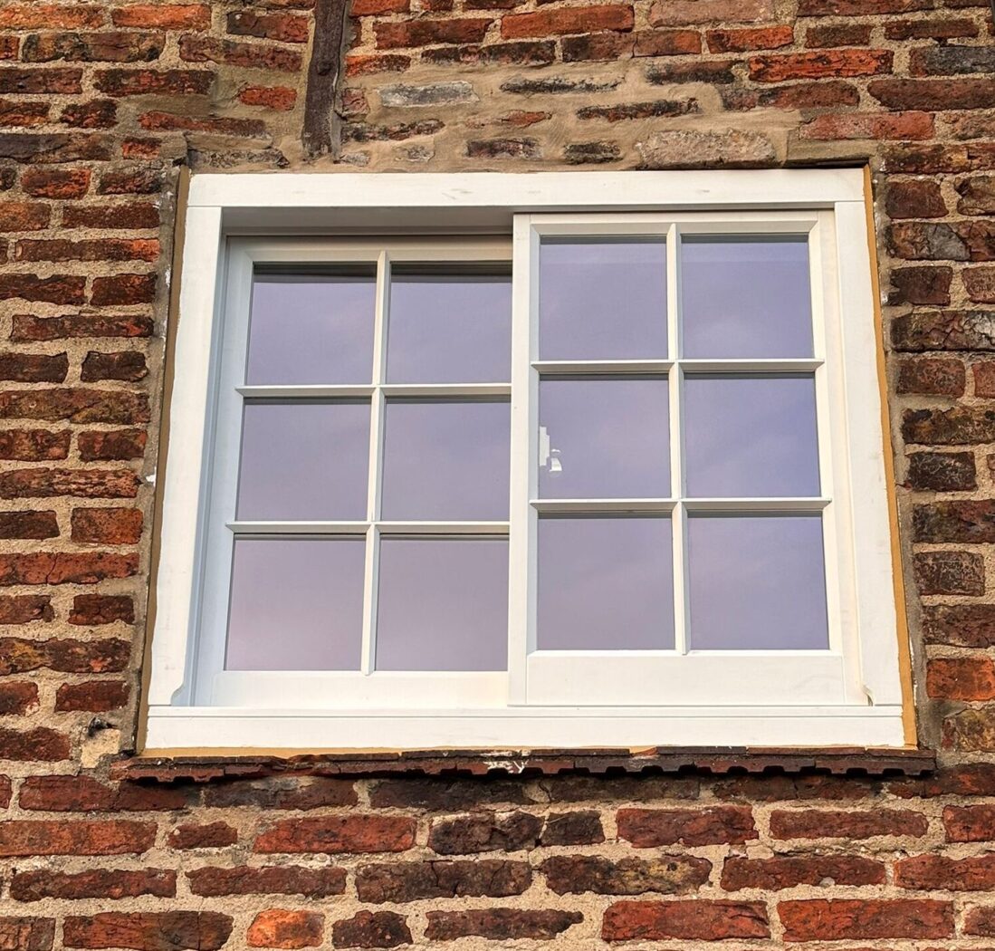 White Accoya Yorkshire Sliding Sash window in a red brick cottage