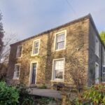 Large stone detached house in golden hour sunlight with new sash windows