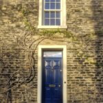 Stone house with a sash window and a Cobalt Blue Georgian six-panel front door.