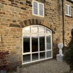 A stone barn conversion in Wath-upon-Dearne with a large arched bespoke window