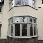 White wash house with Blue grey heritage bay windows