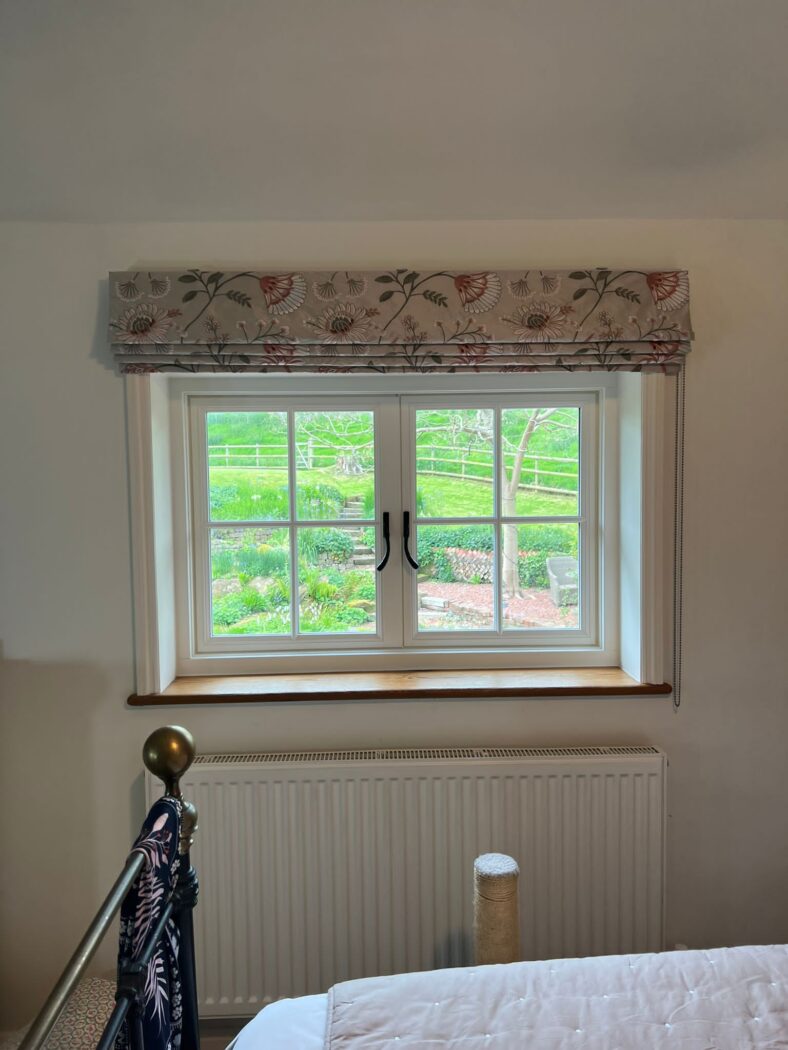 Bedroom with a traditional heritage flush casement window with Georgian bars and black iron hardware