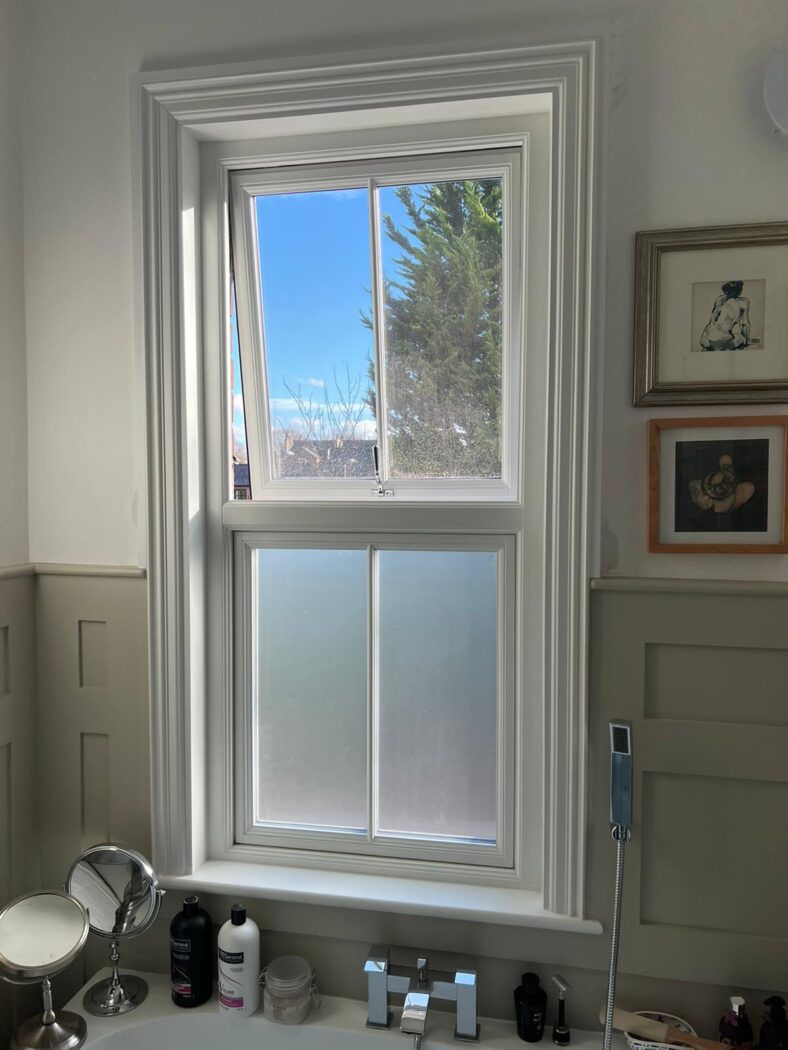 Hinged casement bathroom window. The bottom pane is obscure glass and the top pane is clear glass.