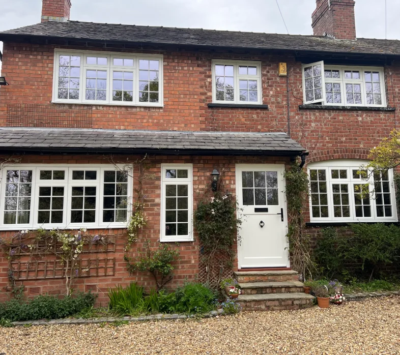 English house with white heritage flush casement windows and timber front door