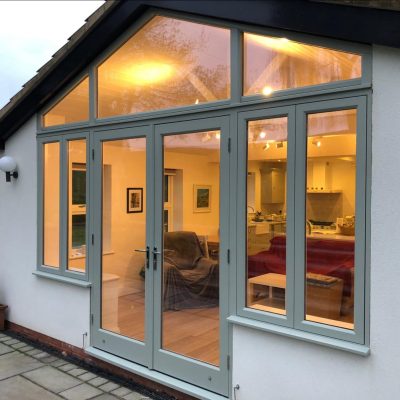 Conservatory with a cosy orange light and a bespoke arched window and door screen