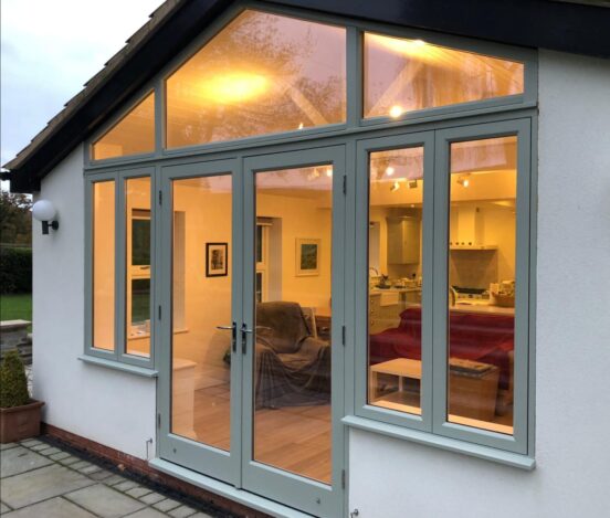 Conservatory with a cosy orange light and a bespoke arched window and door screen