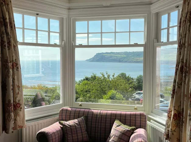 Spiral balance sash window with a view out over Robin Hoods Bay Yorkshire