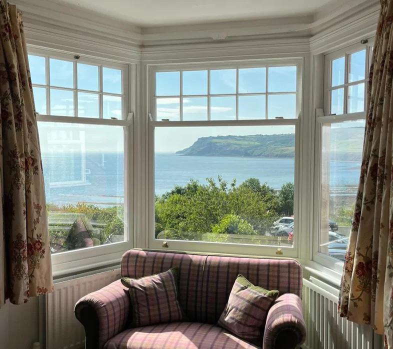 Spiral balance sash window with a view out over Robin Hoods Bay Yorkshire